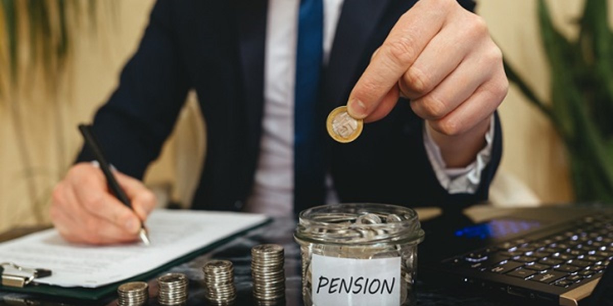 Man placing coins in pension jar
