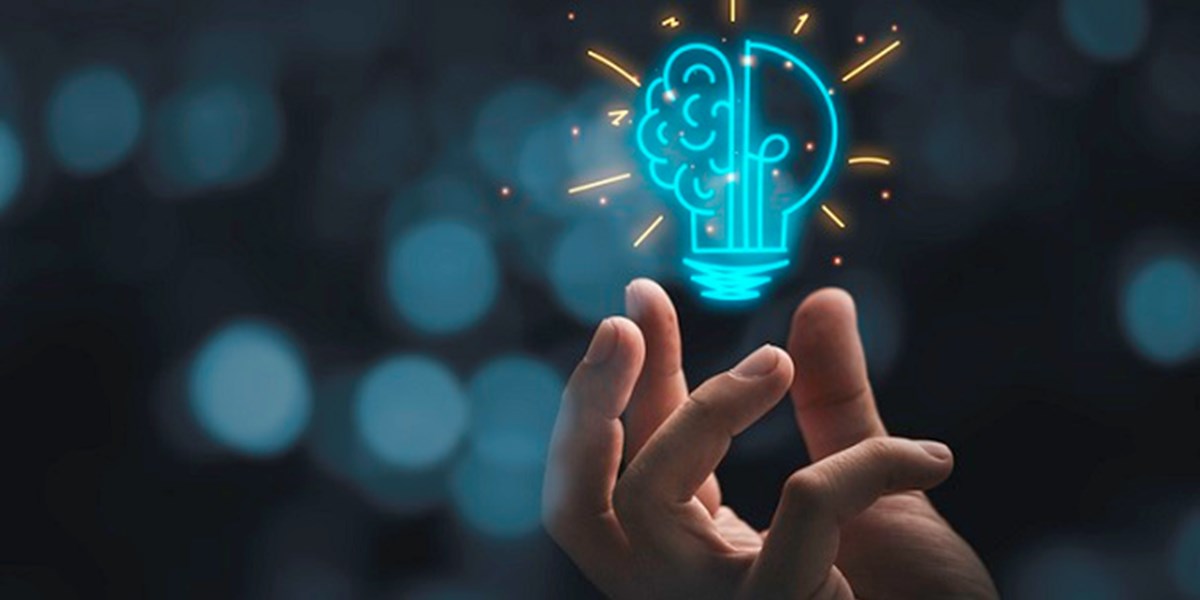 Hand holding half lightbulb, half brain