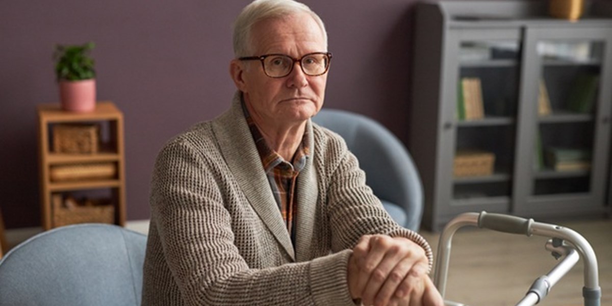 Elderly man at home with walking frame